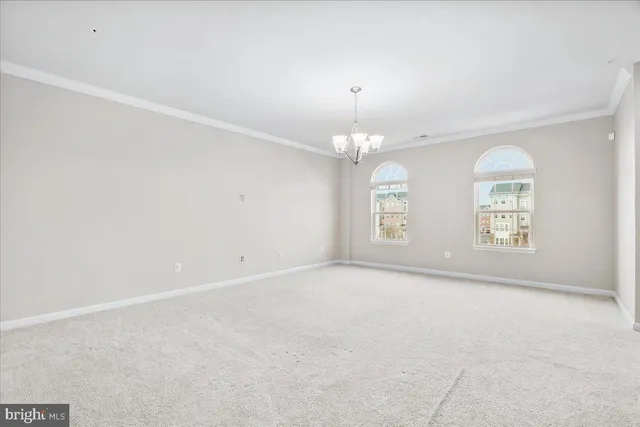 en empty room with windows and chandelier fan