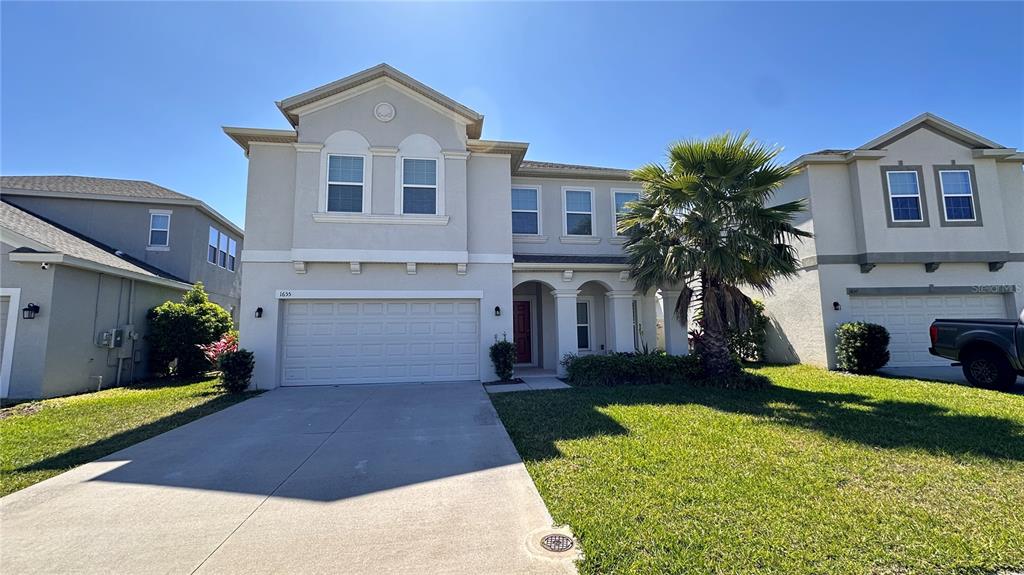 a front view of a house with a yard and garage