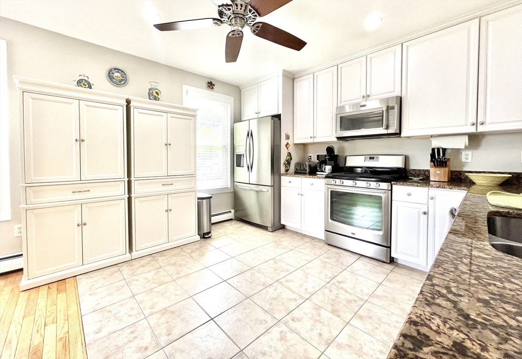 19 Lafayette Road, Unit 3 Ipswich, MA 01938 - Photo 5 of 41 a kitchen with stainless steel appliances kitchen island granite countertop a refrigerator a stove a sink and white cabinets with wooden floor