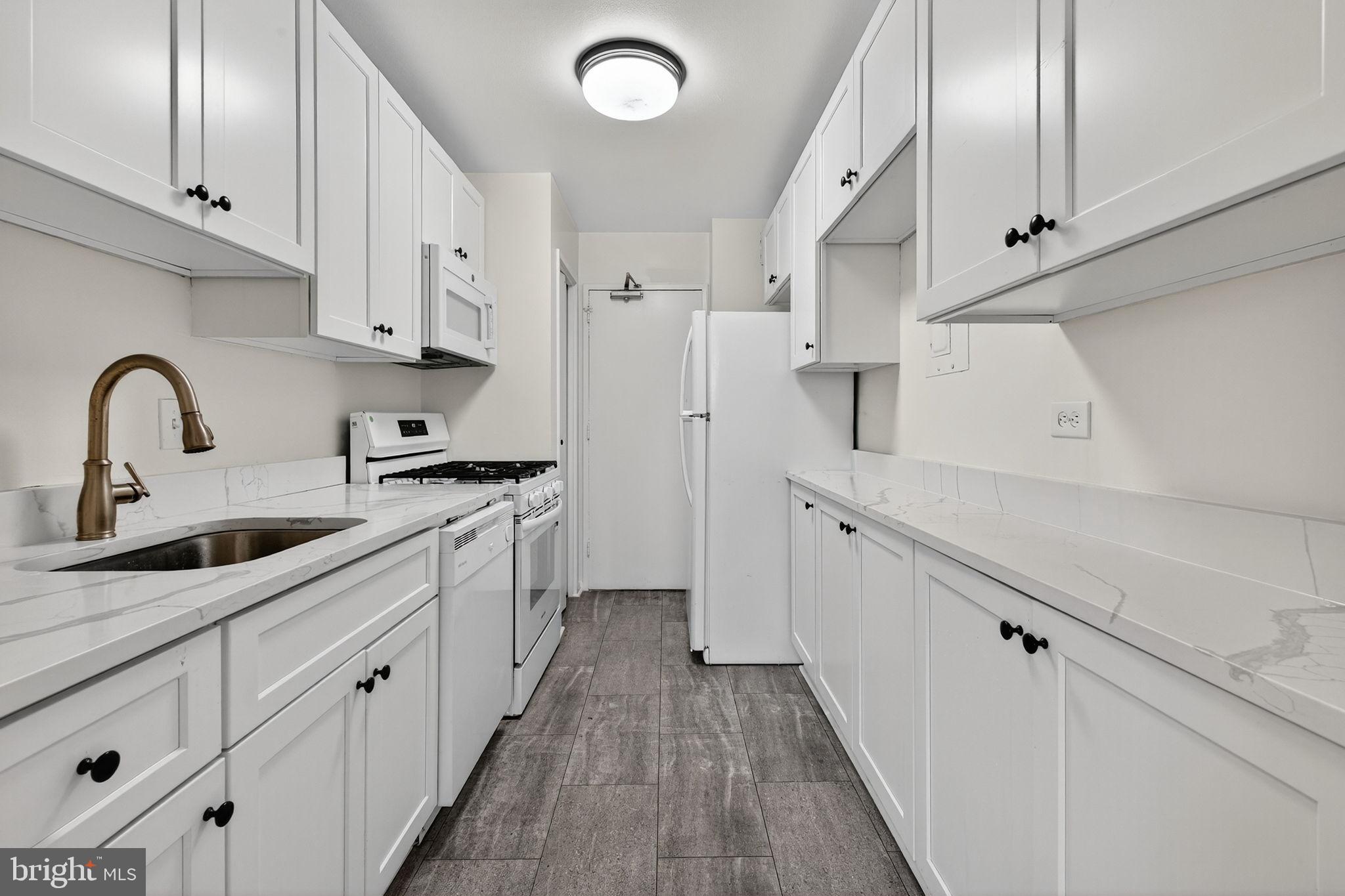 1900 Lyttonsville Road, Unit 618 Silver Spring, MD 20910 - Photo 13 of 36 a kitchen with granite countertop white cabinets and white appliances