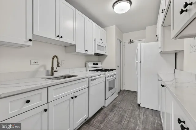 a kitchen with white cabinets and white appliances