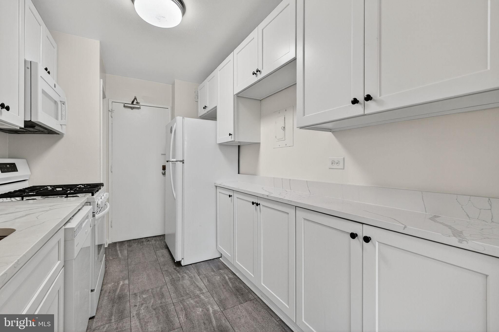 1900 Lyttonsville Road, Unit 618 Silver Spring, MD 20910 - Photo 15 of 36 a kitchen with white cabinets and wooden floor
