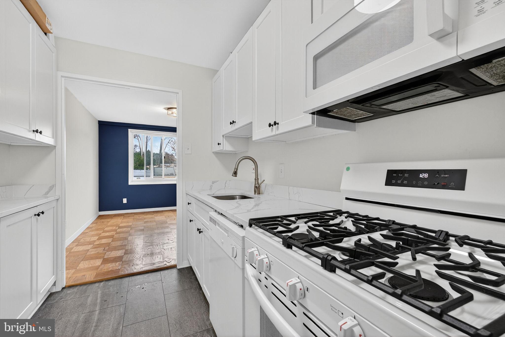 1900 Lyttonsville Road, Unit 618 Silver Spring, MD 20910 - Photo 17 of 36 a kitchen with a stove and a wooden floor