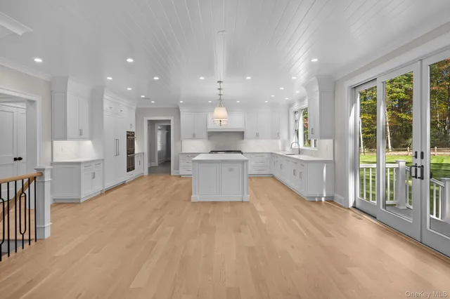 a large kitchen with stainless steel appliances kitchen island granite countertop a large cabinets a sink and a counter top space