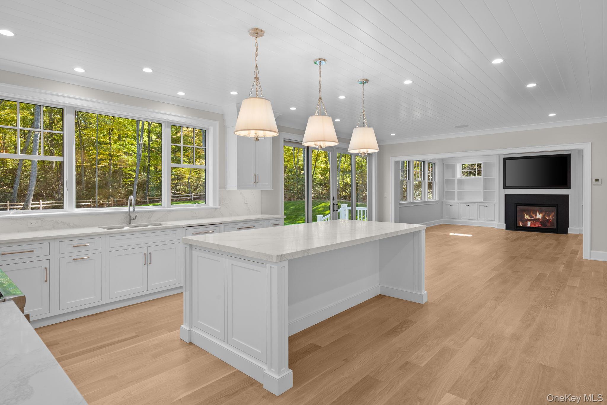 66 Saw Mill Road Cold Spring Harbor, NY 11724 - Photo 14 of 40 a large kitchen with kitchen island white cabinets and wooden floor