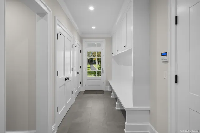 a view of a hallway with white walls and white door