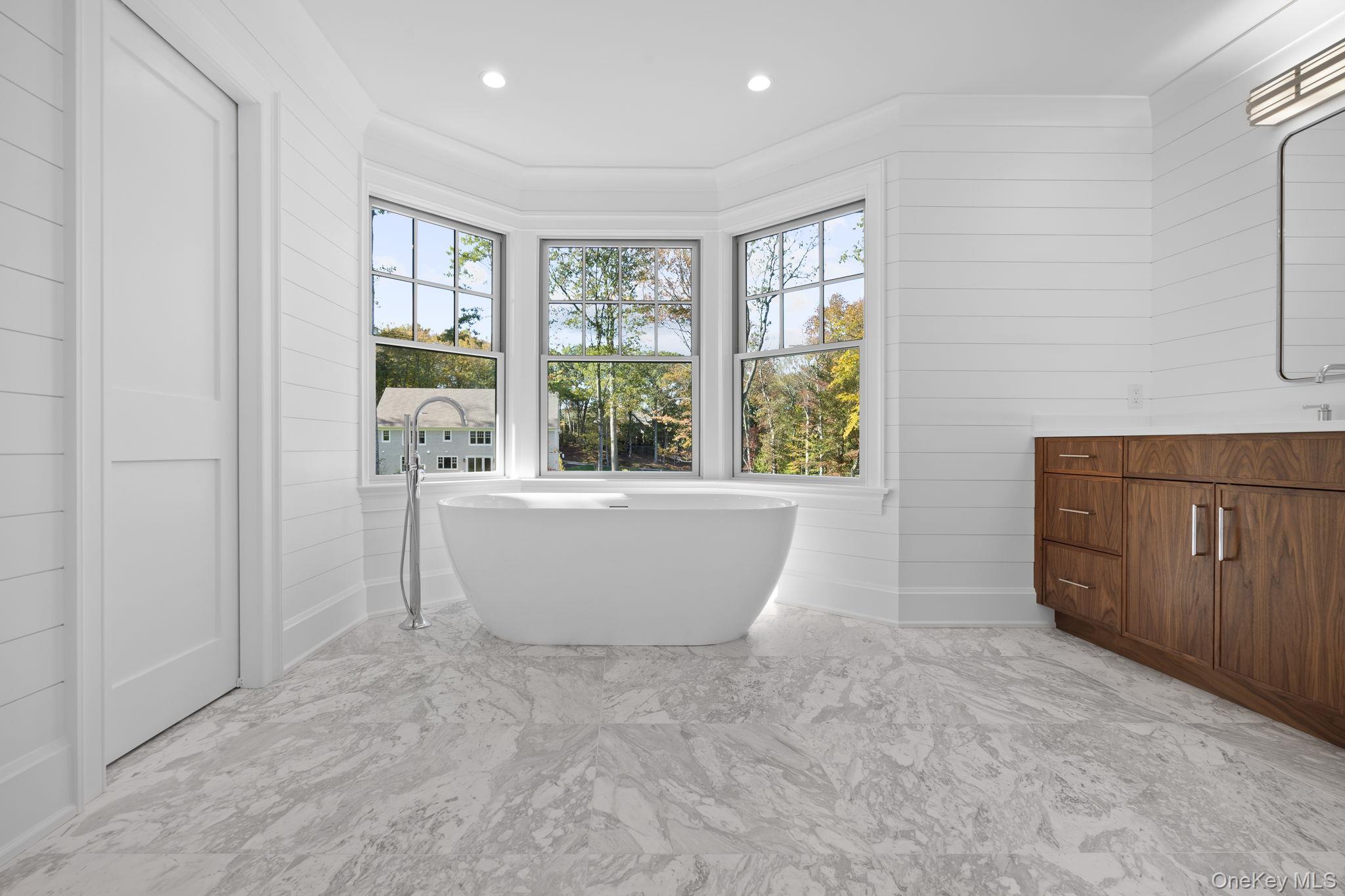 66 Saw Mill Road Cold Spring Harbor, NY 11724 - Photo 26 of 40 a large white tub sitting in a room next to a window