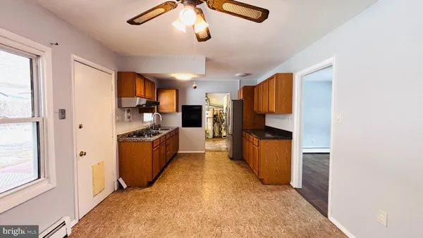 a kitchen with stainless steel appliances kitchen island granite countertop a refrigerator and a stove top oven