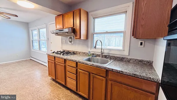 a kitchen with stainless steel appliances granite countertop a sink stove and cabinets