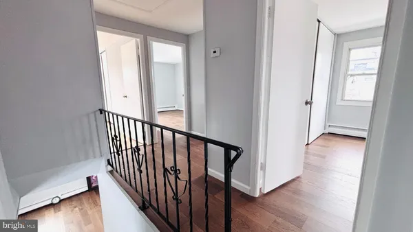 a view of a hallway with wooden floor and stairs