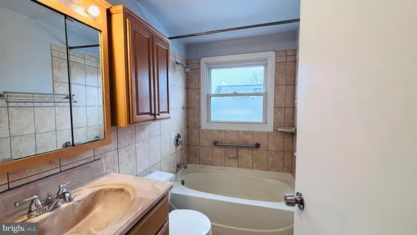 a bathroom with a tub sink and mirror