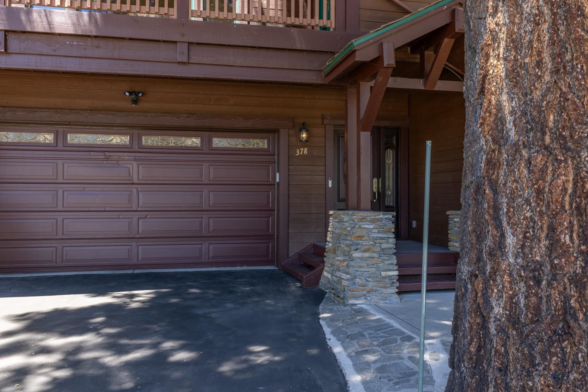 378 Ridge Way Mammoth Lakes, CA 93546 - Photo 3 of 43 Brown paneled garage door with decorative glass inserts