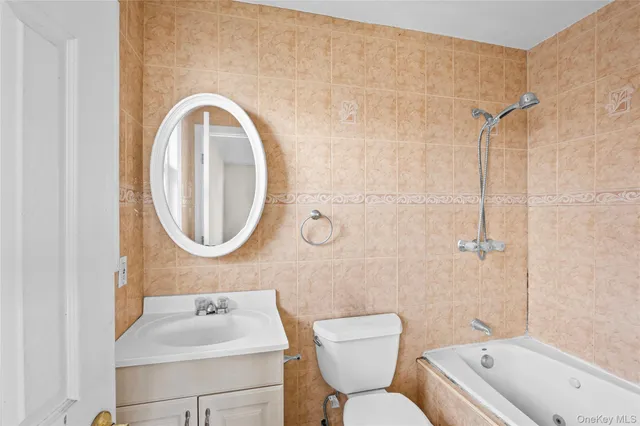 a bathroom with a toilet a sink a mirror and bathtub