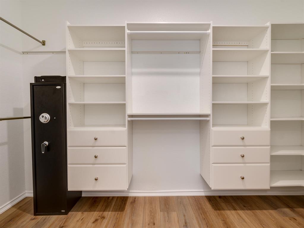 1208 Sweetspire Street Leander, TX 78641 - Photo 18 of 36 Custom closet system featuring white shelving units, integrated drawers with brushed nickel hardware, and hanging rods