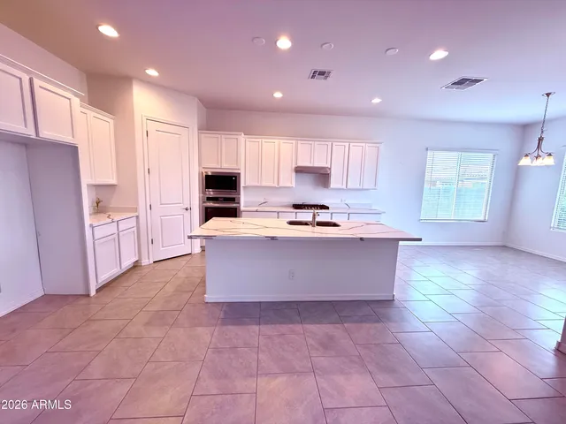 a large kitchen with kitchen island granite countertop a large counter top stainless steel appliances and cabinets