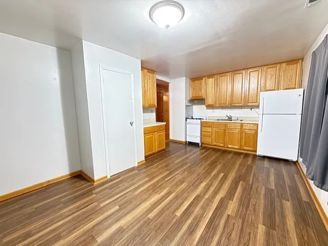 a view of a kitchen with wooden floor and a window