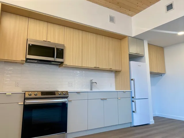 a kitchen with stainless steel appliances a stove microwave and sink