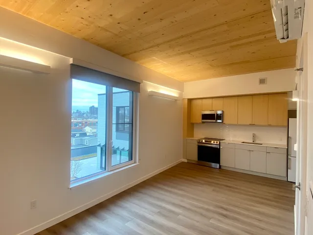 a view of a kitchen with wooden floor and a sink