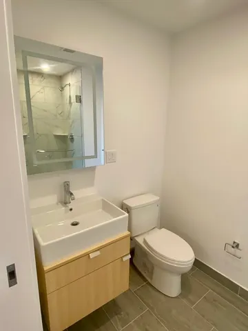 a white toilet sitting next to a bathroom sink