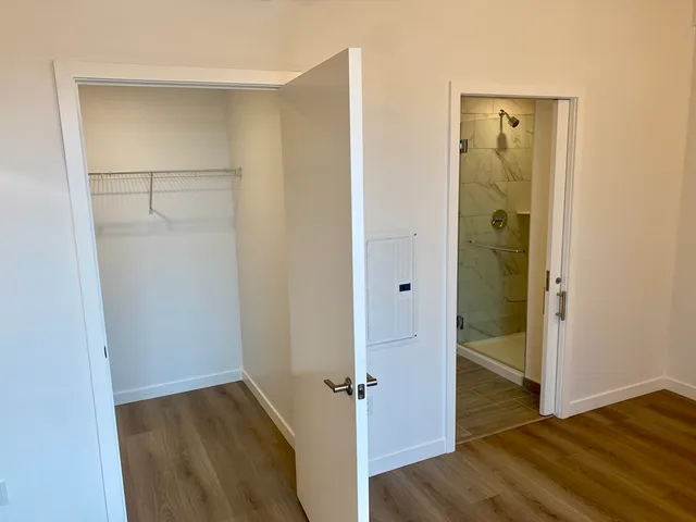 an empty room with wooden floor and closet