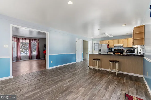 a view of a kitchen with furniture and wooden floor