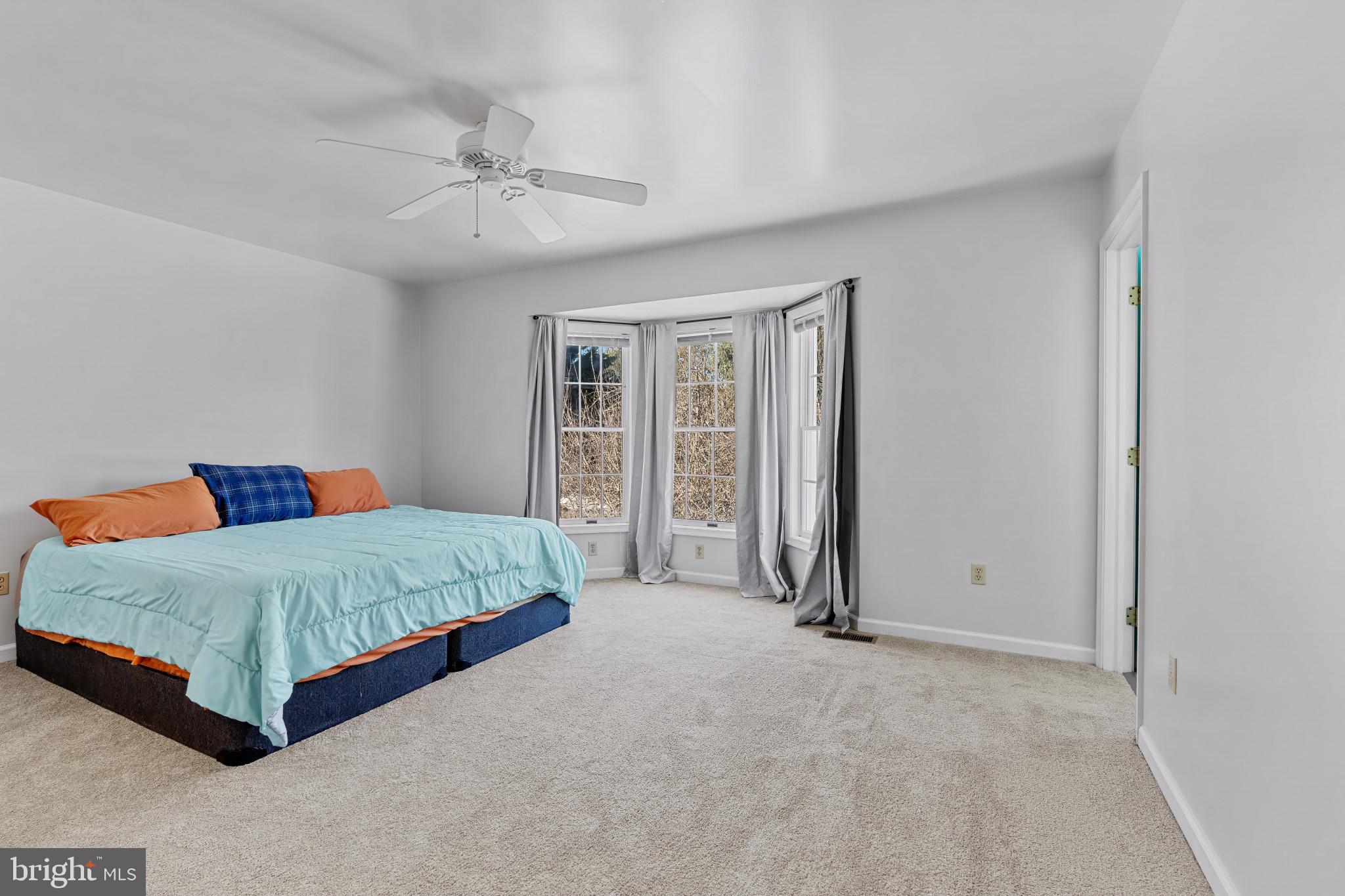 14525 John Peel Road Galena, MD 21635 - Photo 15 of 31 a spacious bedroom with a bed and a chandelier