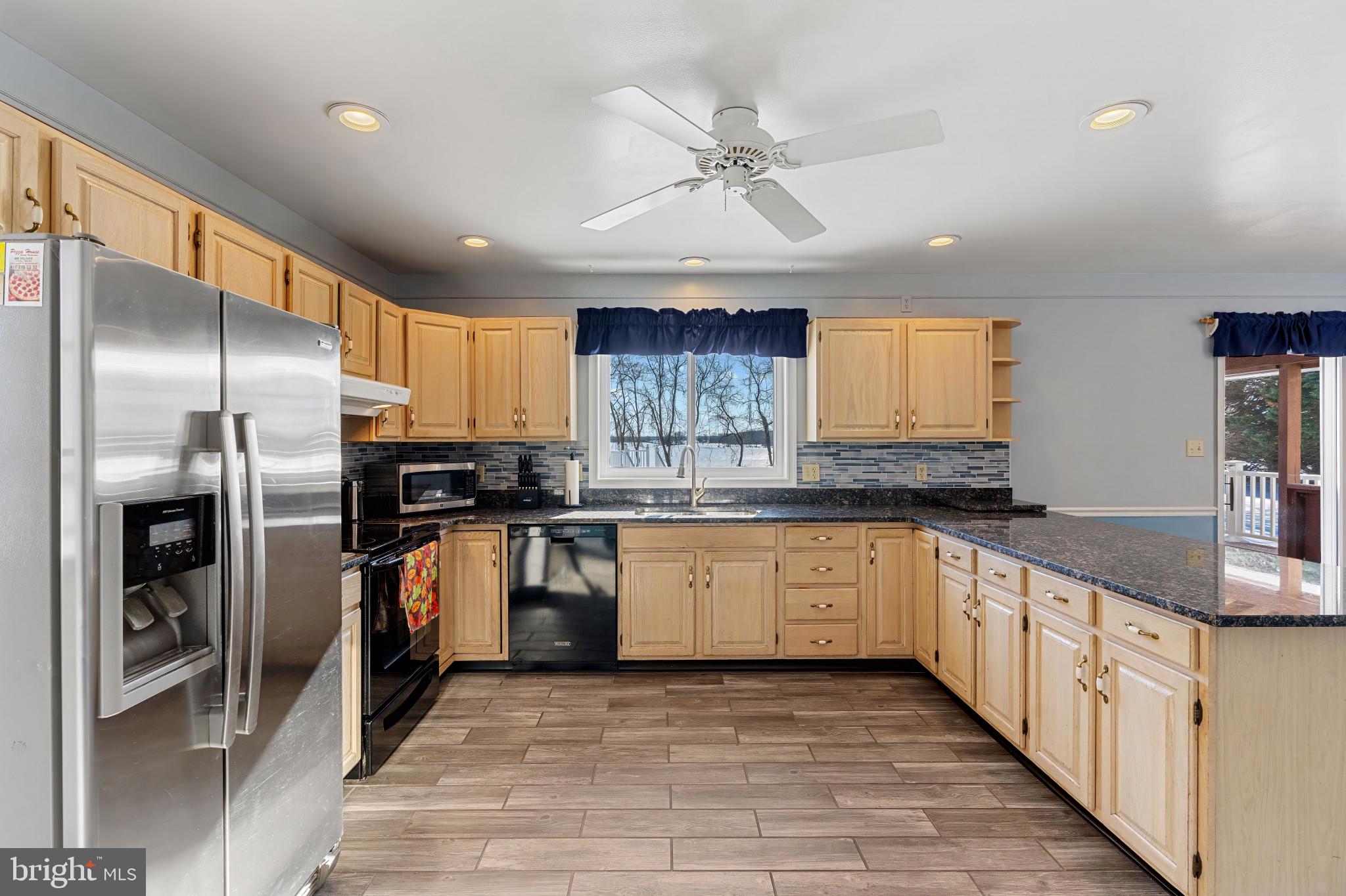14525 John Peel Road Galena, MD 21635 - Photo 6 of 31 a kitchen with stainless steel appliances granite countertop a refrigerator a sink and white cabinets
