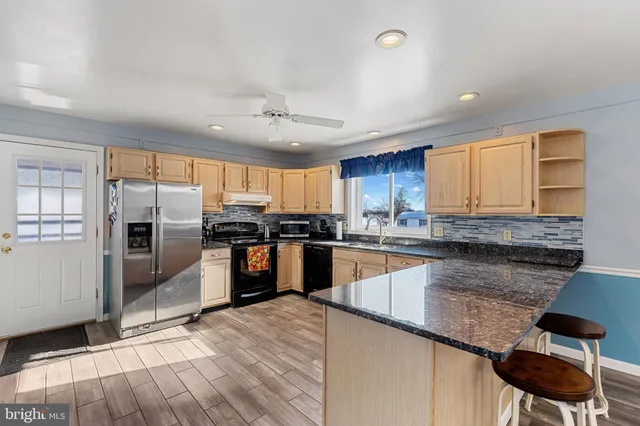 a kitchen with granite countertop stainless steel appliances and wooden cabinets