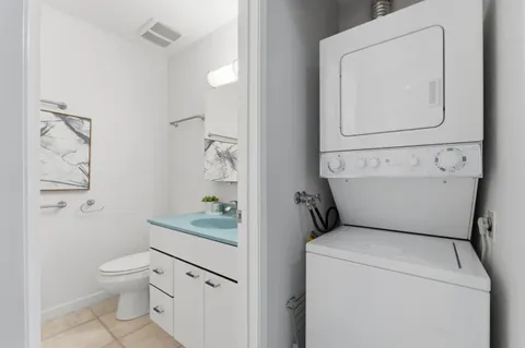 a bathroom with a granite countertop toilet sink and mirror