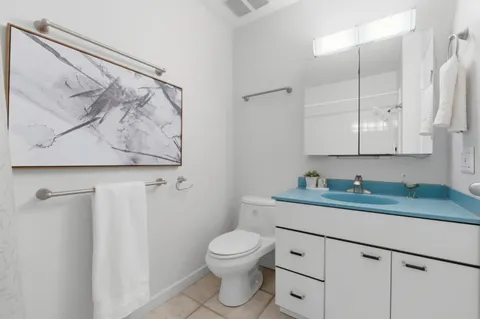 a bathroom with a granite countertop sink a toilet and a mirror