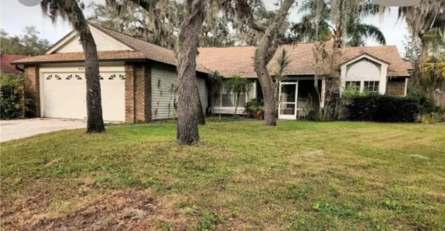 a front view of a house with yard and tree