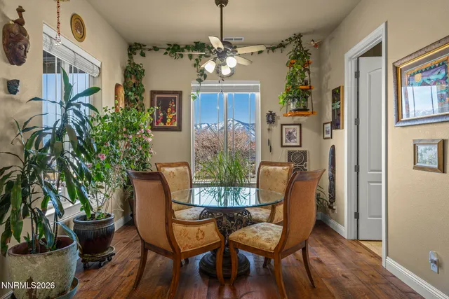 a dining room with furniture potted plants and wooden floor