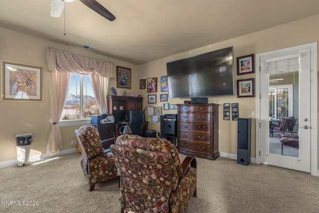 a living room with furniture a flat screen tv and a large window