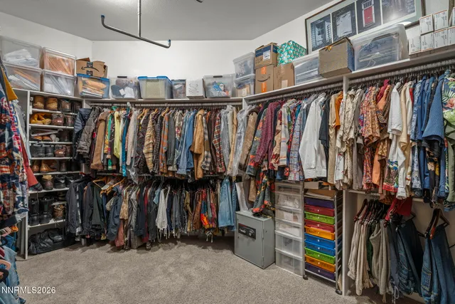 a view of walk in closet with clothes and shoes