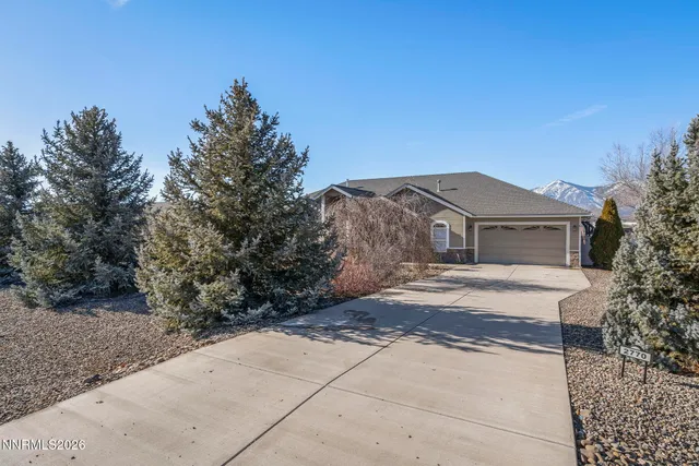 a front view of a house with a yard and trees