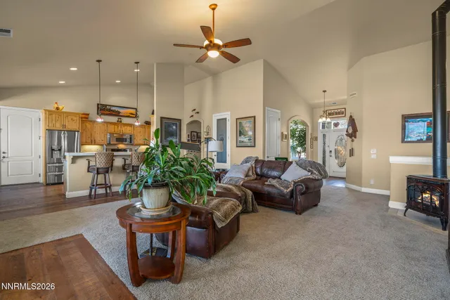 a living room with furniture kitchen view and a chandelier