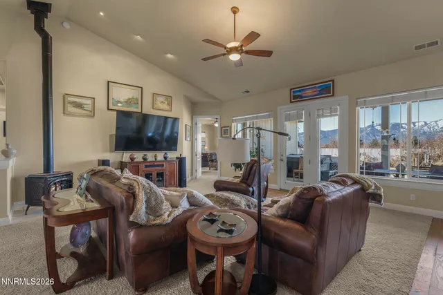 a living room with furniture a flat screen tv and a large window