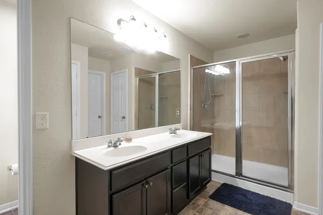 a bathroom with a double vanity sink toilet and shower