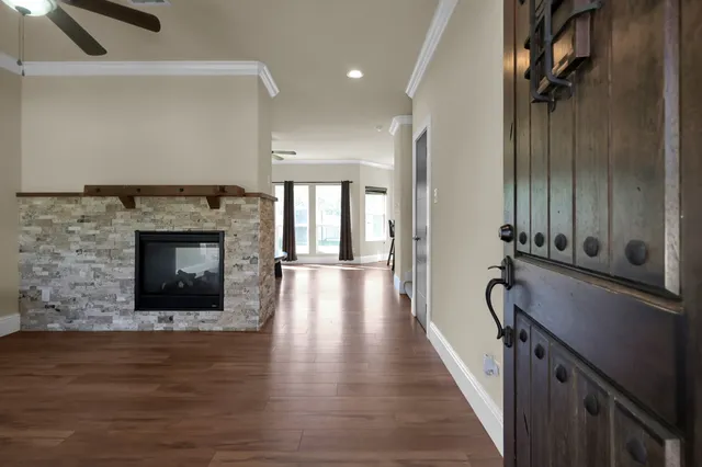 a hallway with a fireplace and a wooden floor