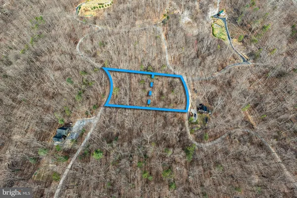 a view of a dry field with mountains in the background