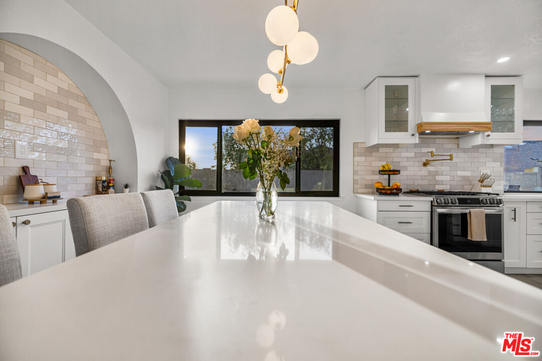2313 Rynerson Court Simi Valley, CA 93065 - Photo 13 of 45 a kitchen with stainless steel appliances granite countertop a stove top oven a sink a dining table and chairs with wooden floor