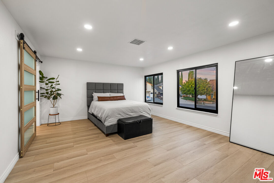 2313 Rynerson Court Simi Valley, CA 93065 - Photo 23 of 45 a spacious bedroom with a large bed and a wooden floor