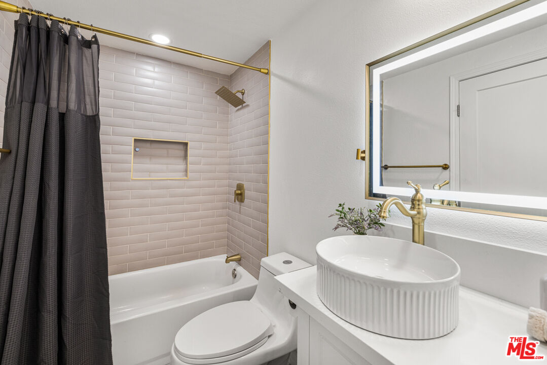 2313 Rynerson Court Simi Valley, CA 93065 - Photo 34 of 45 a bathroom with a sink a bathtub a mirror a toilet and a shower