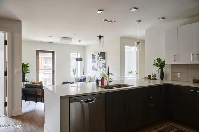 a living room with furniture and potted plants
