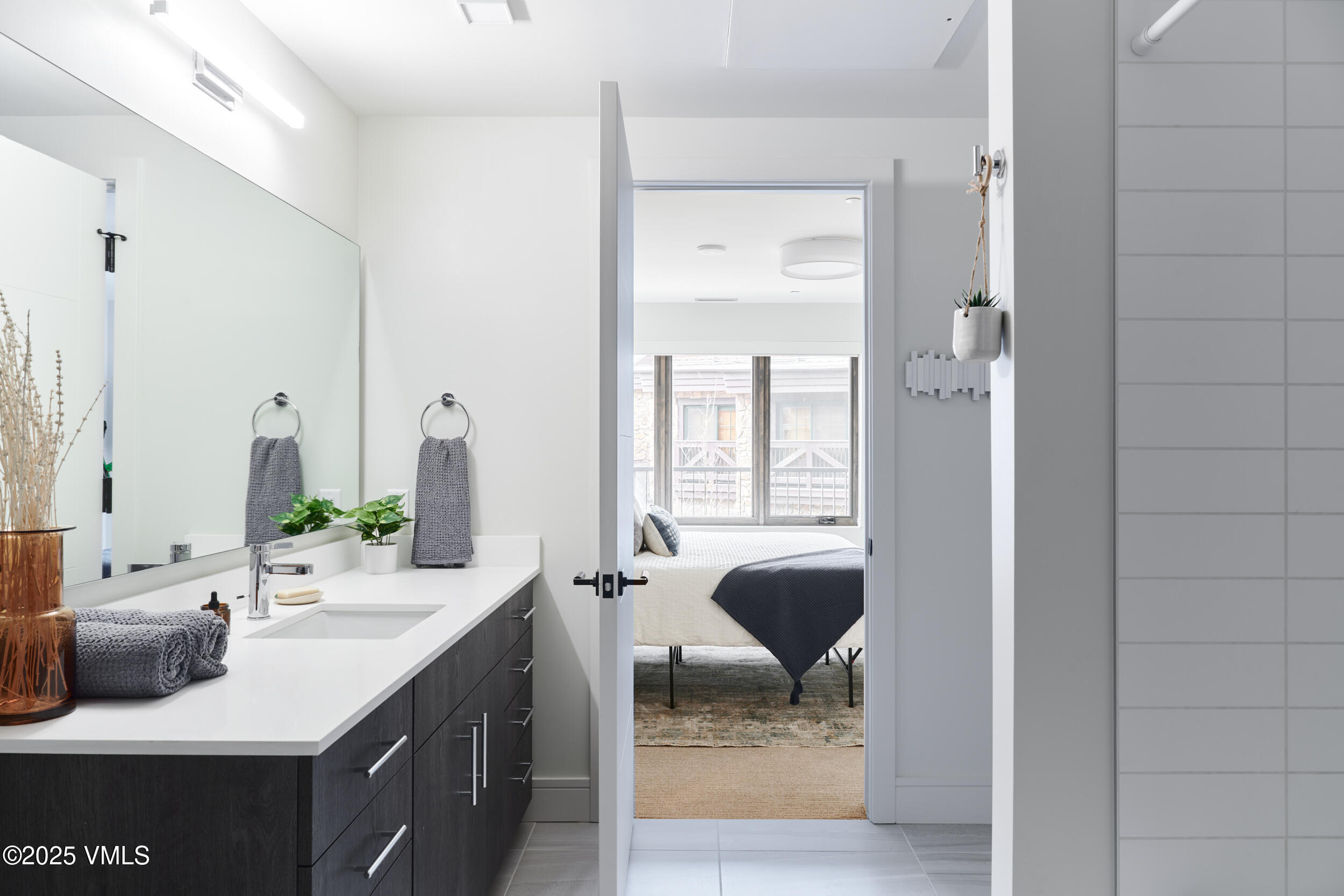 430 South Frontage Road East, Unit RUD Vail, CO 81657 - Photo 6 of 8 a en suite bathroom with a granite countertop sink and a mirror