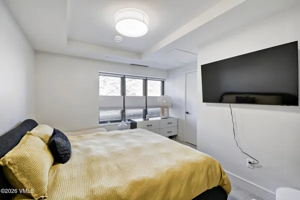 a kitchen with stainless steel appliances a sink a stove a microwave a center island and living room view