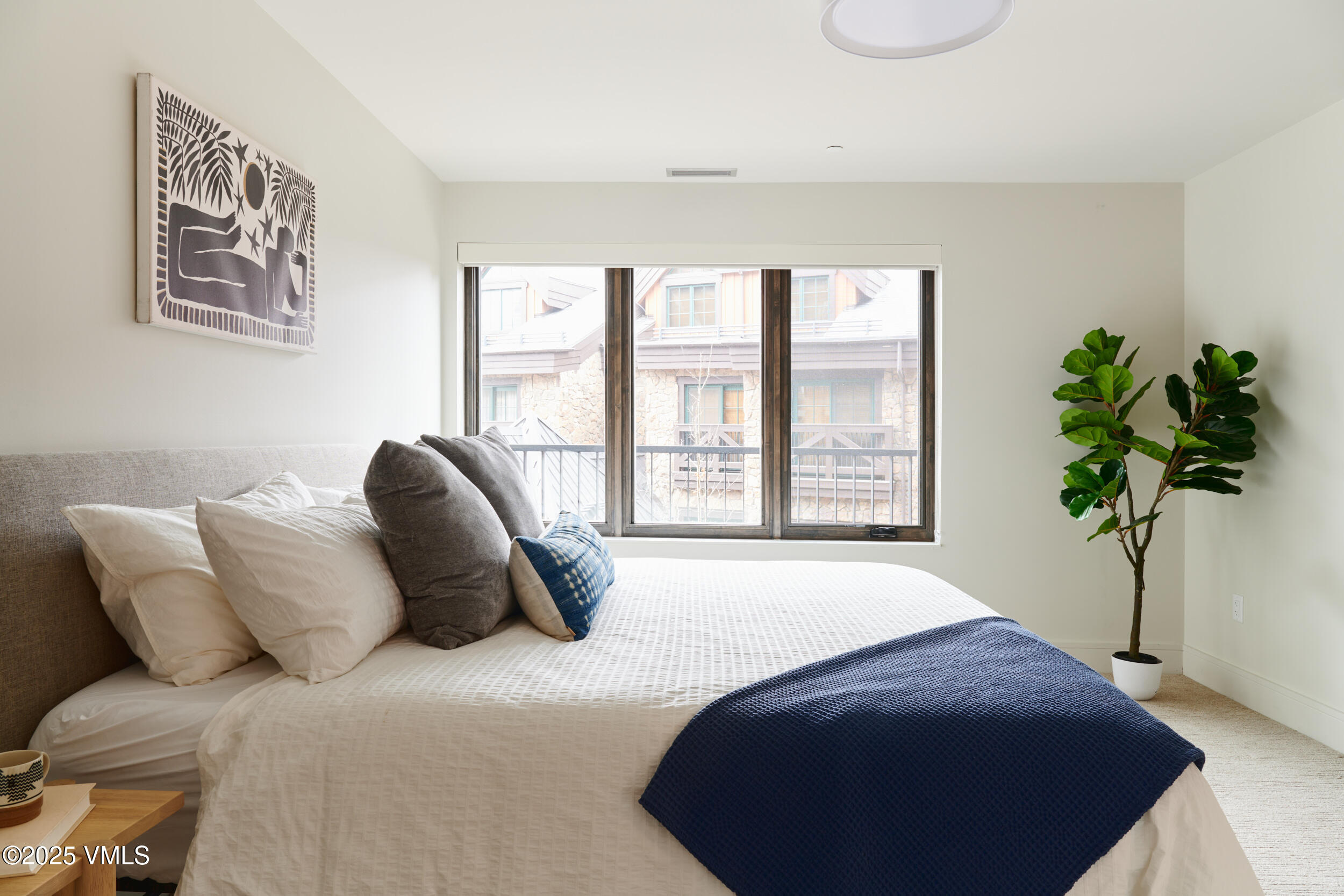 430 South Frontage Road East, Unit RUD Vail, CO 81657 - Photo 8 of 8 a bedroom with a bed lamp and a potted plant