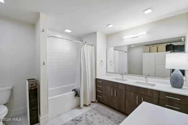a bathroom with a sink toilet vanity and shower