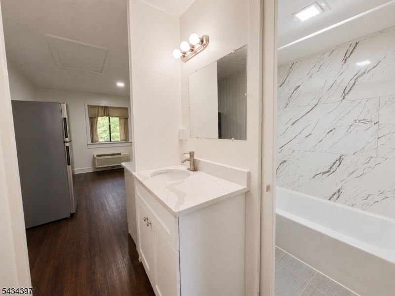 207 Old Chimney Ridge Road, Unit L Montague, NJ 07827 - Photo 11 of 14 a bathroom with a bathtub a sink and a mirror