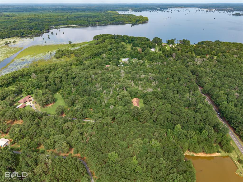 11015 Hereford Road Mooringsport, LA 71060 - Photo 15 of 18 Expansive wooded property featuring a lakefront setting, mature trees, and a visible residential structure